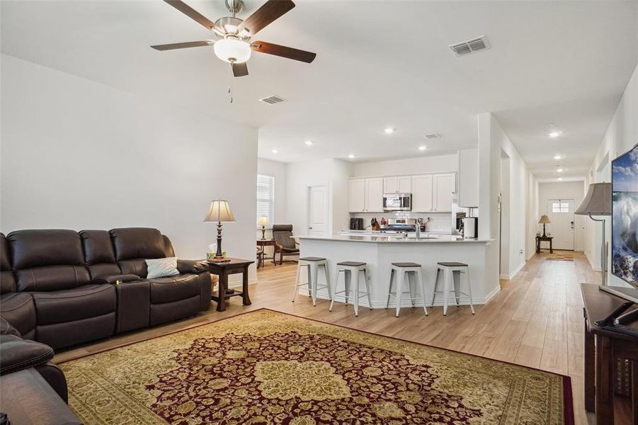 Living room featuring ceiling fan, light hardwood / wood-style flooring, and sink