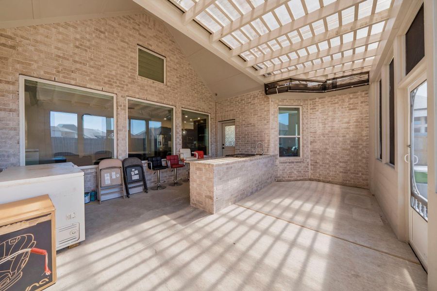 Extended covered patio with built-in outdoor kitchen, perfect for entertaining and enjoying year-round outdoor living.