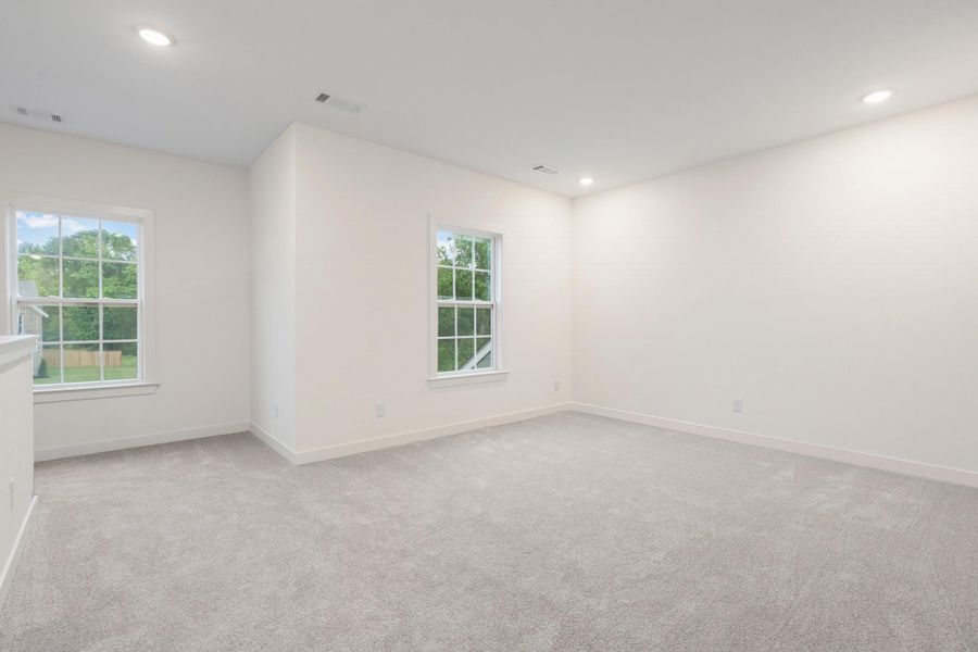 Carpeted room with recessed lighting, two windows with grid patterns, and white trim Carpeted room with recessed lighting, two windows with grid patterns, and white trim