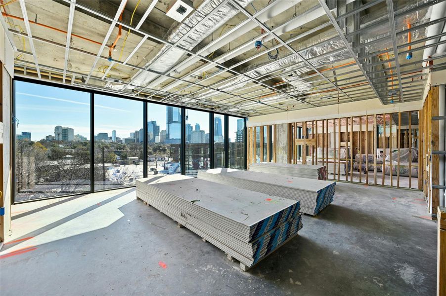 Unfurnished bedroom with a view of city and concrete flooring