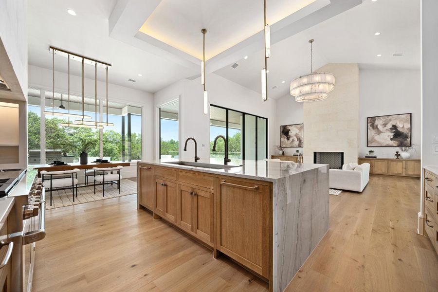 Natural light floods this open-concept home, highlighting a grand kitchen island and living area.