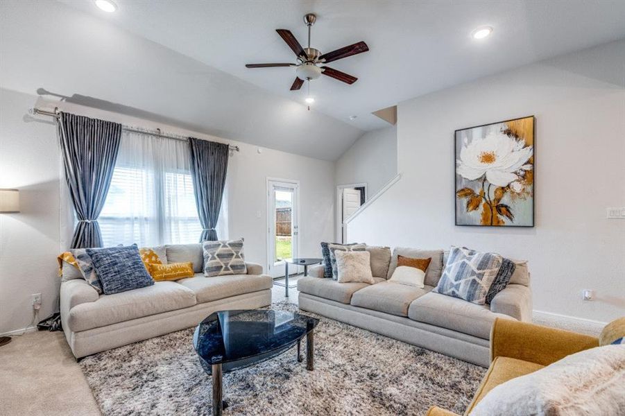 Living area featuring a ceiling fan, vaulted ceiling, carpet flooring, and recessed lighting