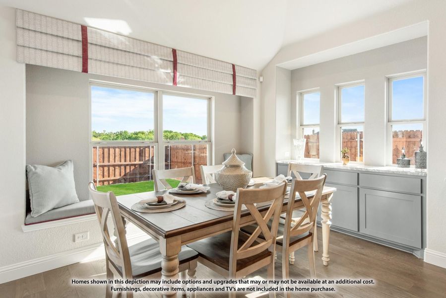Bright dining area with wood table, built-in window seat, and multiple windows overlooking backyard Bright dining area with wood table, built-in window seat, and multiple windows overlooking backyard