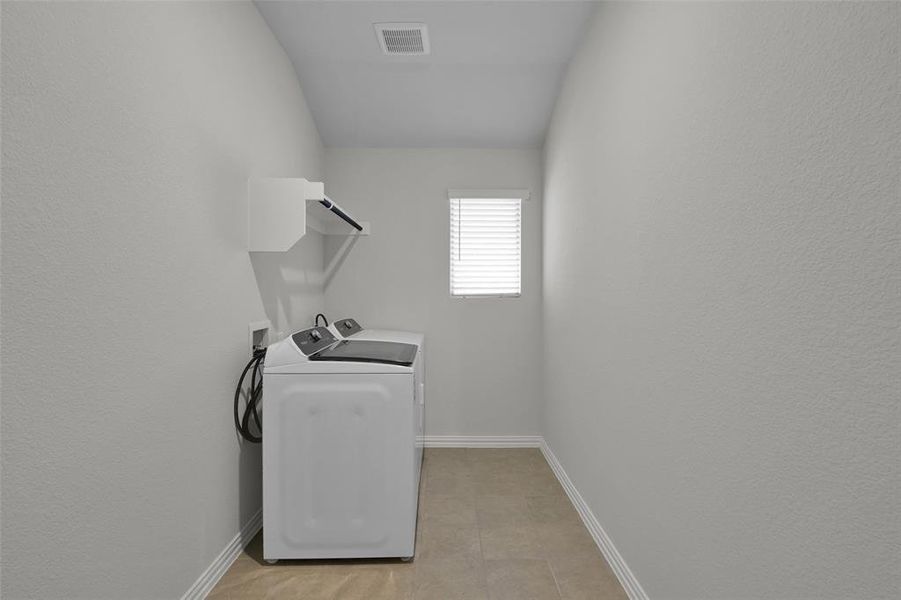 Laundry room with washer and dryer and a textured wall Laundry room with washer and dryer and a textured wall