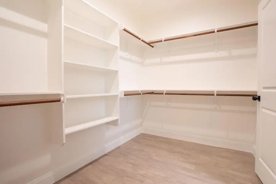 Spacious closet with light wood-style floors Spacious closet with light wood-style floors