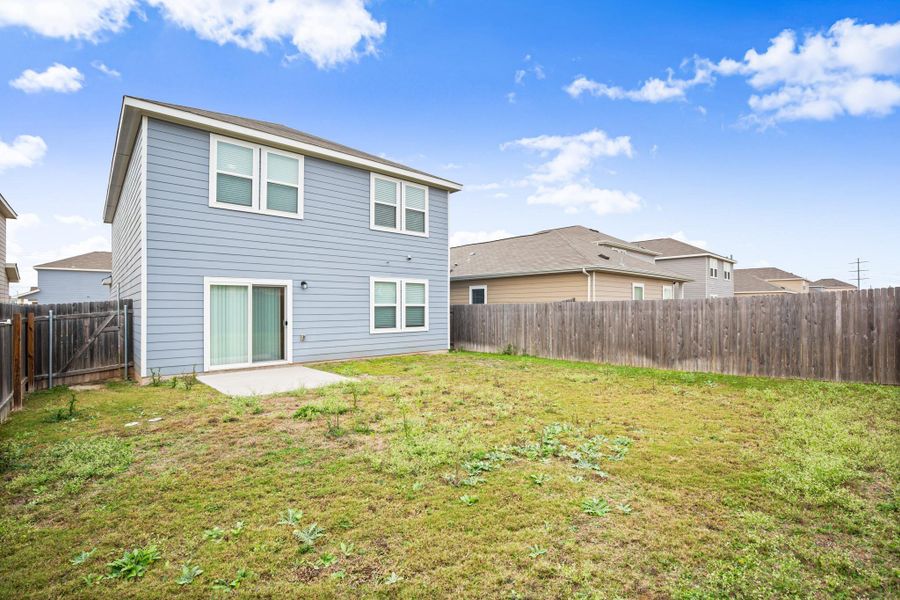 Rear view of house featuring a patio and a fenced backyard