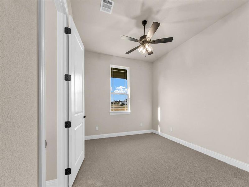 Carpeted spare room featuring ceiling fan