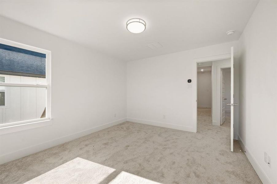 Spare room with light colored carpet and baseboards