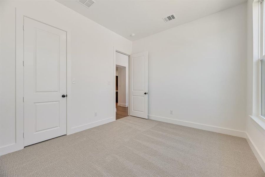 Unfurnished bedroom with light carpet and baseboards Unfurnished bedroom with light carpet and baseboards