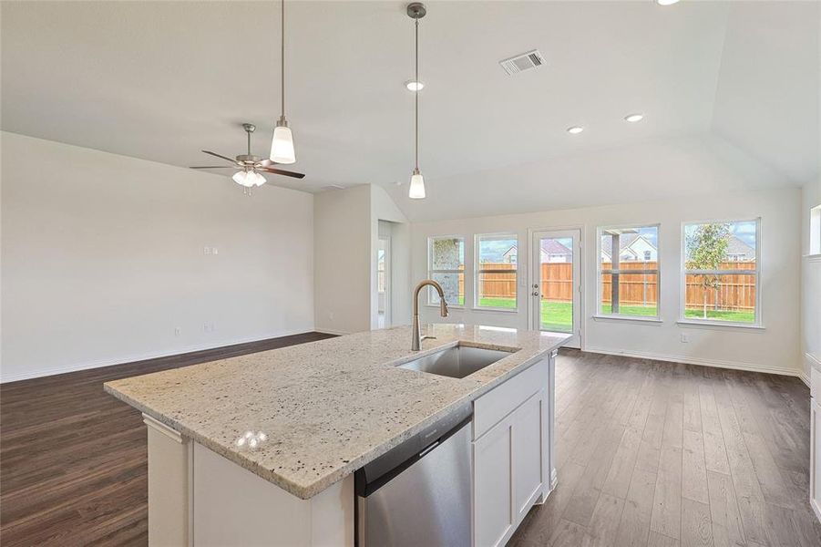 Kitchen with sink, dark wood-type flooring, a kitchen island with sink, and stainless steel dishwasher