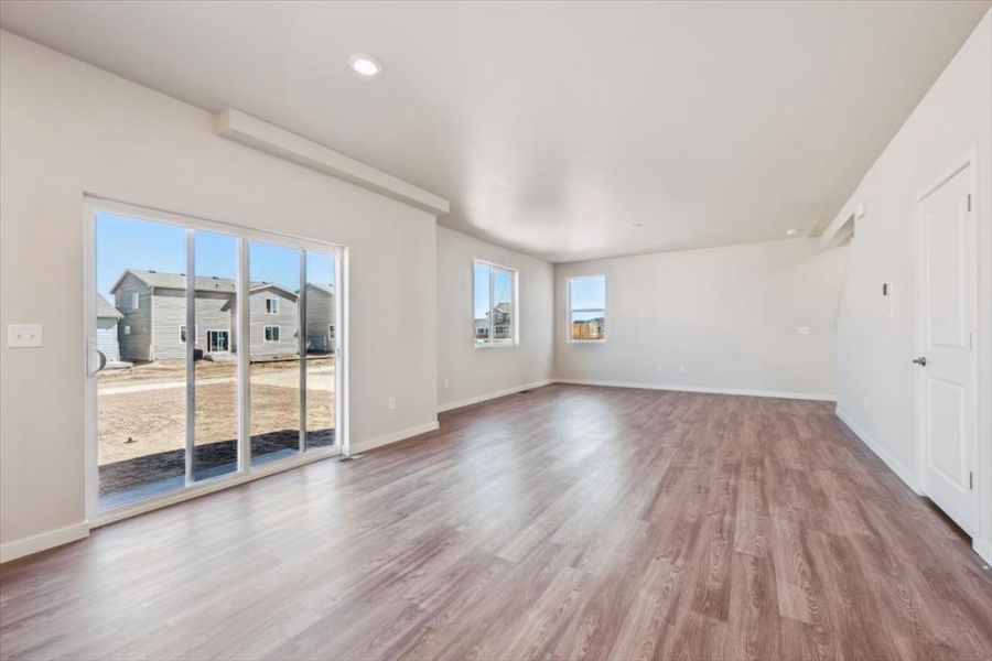 A room with a wood floor and a wood floor with a large window.