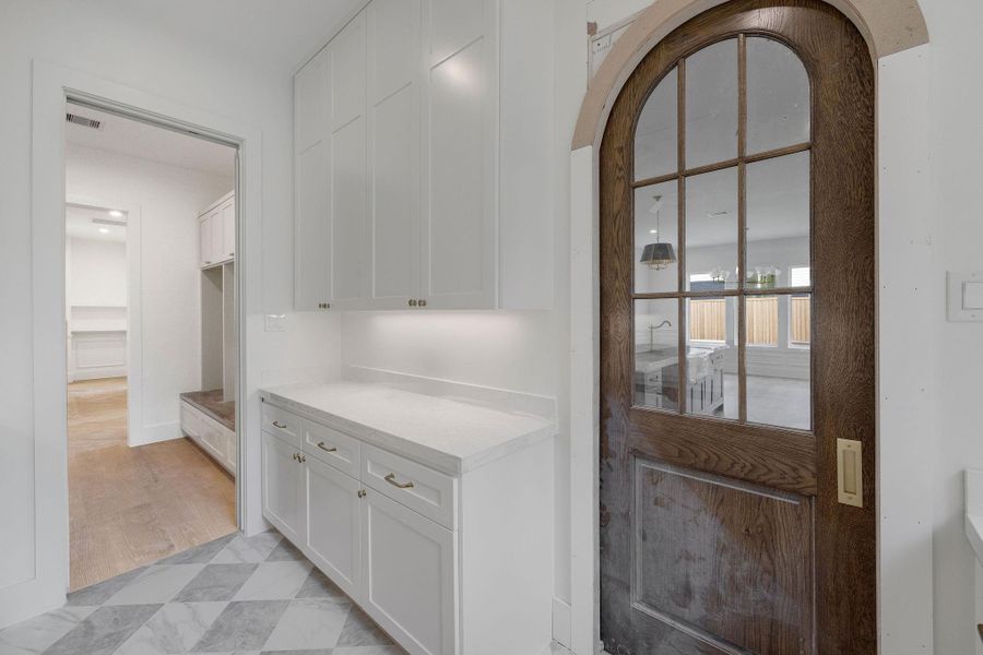 View of the scullery/prep kitchen with a peek into the mud room - notice the character the arched door provides. View of the scullery/prep kitchen with a peek into the mud room - notice the character the arched door provides.