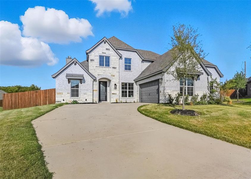French country home featuring stone siding, concrete driveway, a chimney, roof with shingles, and an attached garage