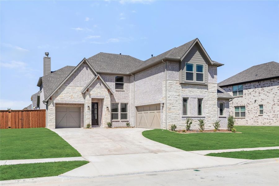 Two-story home with brick and stone exterior, three-car garage, and manicured front lawn Two-story home with brick and stone exterior, three-car garage, and manicured front lawn