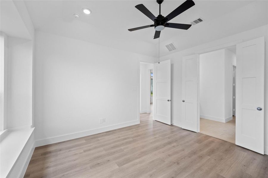 Additional view from primary bedroom looking towards the double door entrance to primary bathroom.
