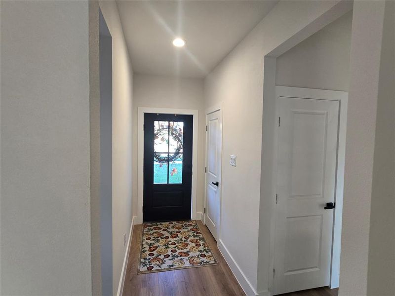 Doorway to outside with wood finished floors and recessed lighting