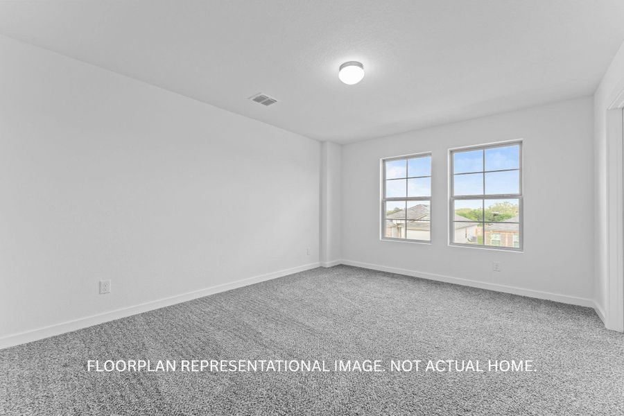 A spacious, naturally illuminated room presents clean walls and durable carpeting.