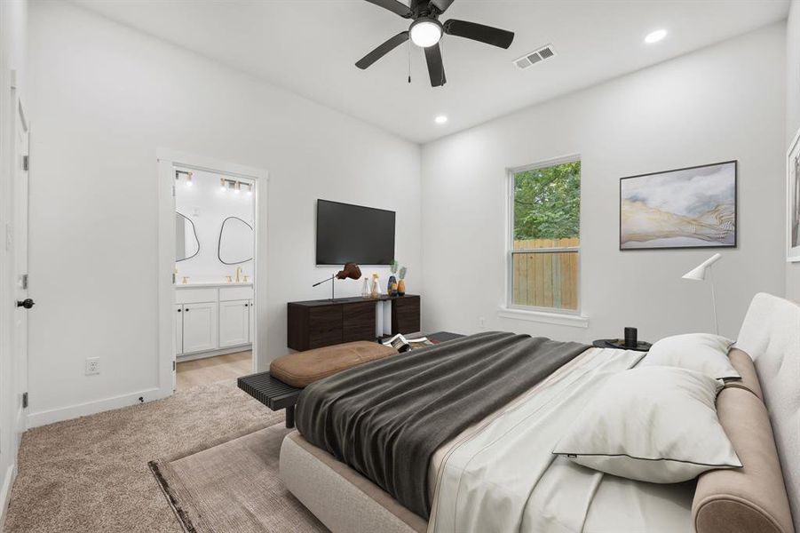 Bedroom with sink, light colored carpet, ensuite bath, and ceiling fan