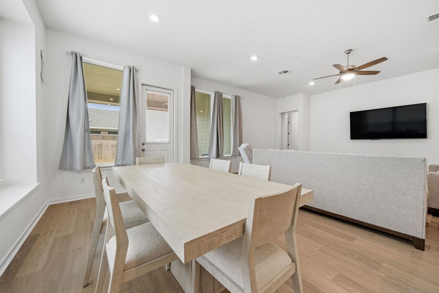 Dining room with light wood-style flooring, ceiling fan, and recessed lighting