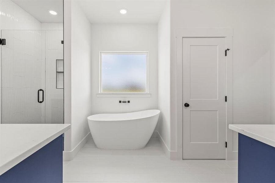 Bathroom with a freestanding tub, a shower stall, vanity, tile patterned floors, and recessed lighting