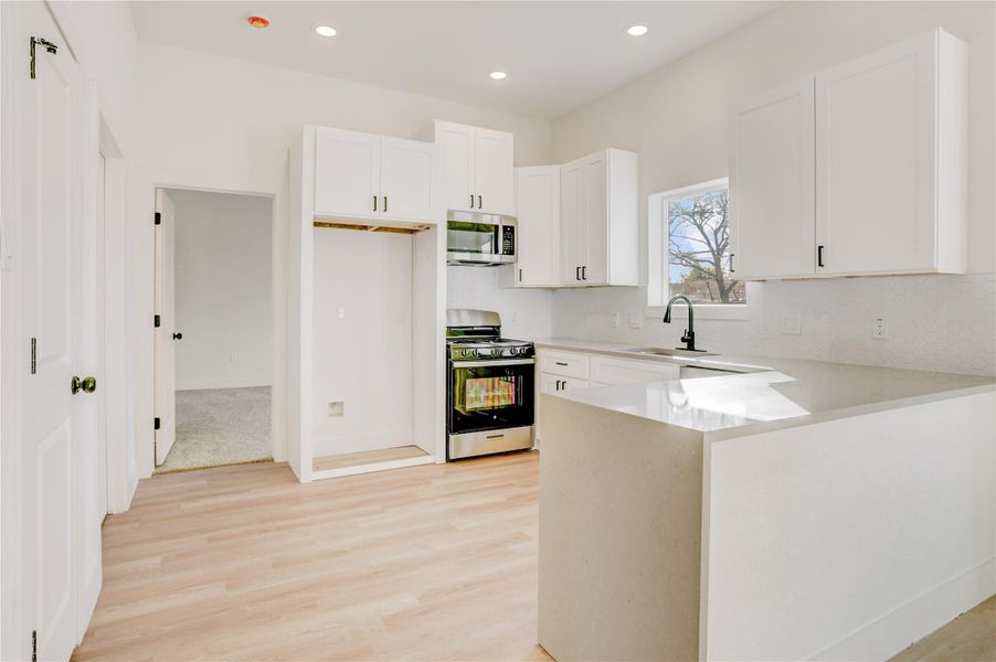 Open Concept living, kitchen is open to family room, home includes a suite of Samsung appliances including microwave, range, and dishwasher.