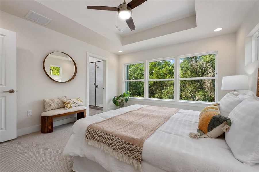 Tray ceilings and wall of large windows provide a feeling of spaciousness.