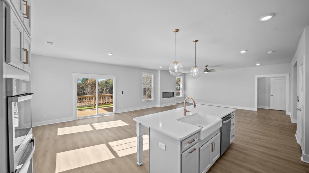 Vibrant and open gourmet kitchen centered around a 8-foot island with elegant pendant lighting above