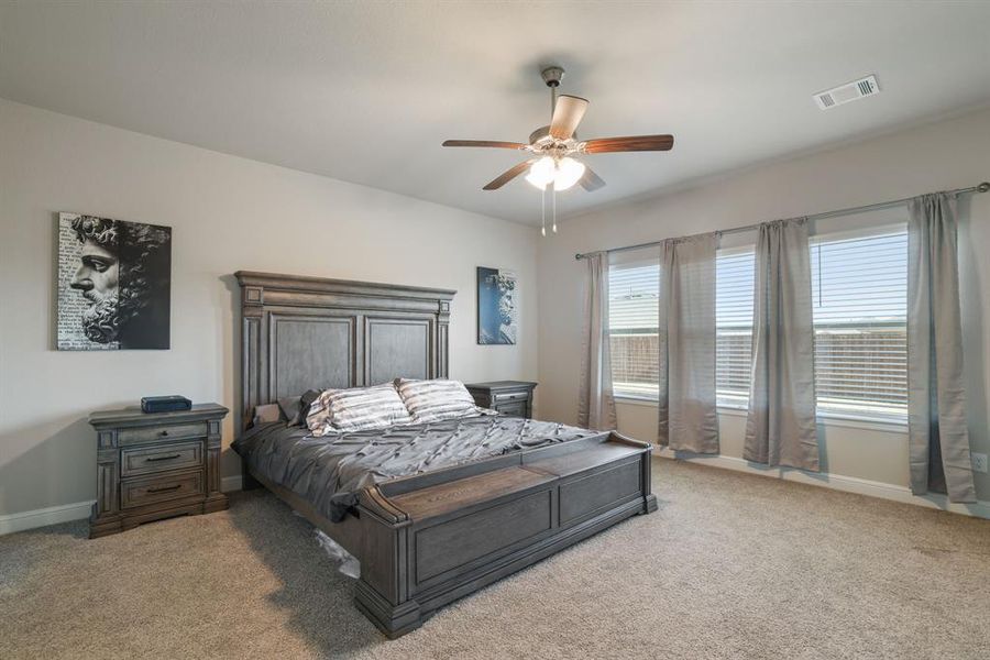 Bedroom featuring light carpet and ceiling fan Bedroom featuring light carpet and ceiling fan