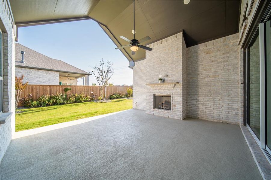 View of patio / terrace featuring a ceiling fan and an outdoor brick fireplace View of patio / terrace featuring a ceiling fan and an outdoor brick fireplace