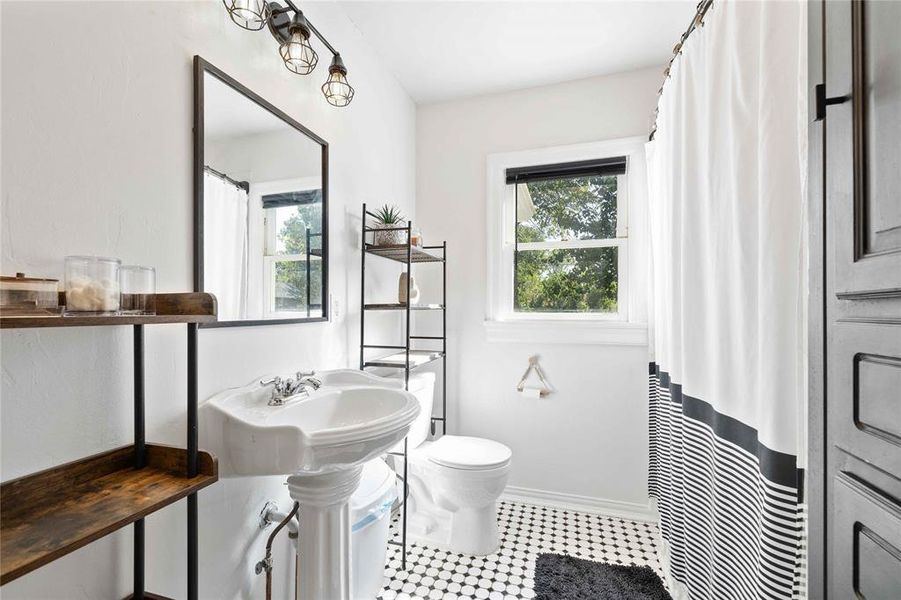 Full bathroom with toilet and a shower with shower curtain Full bathroom with toilet and a shower with shower curtain