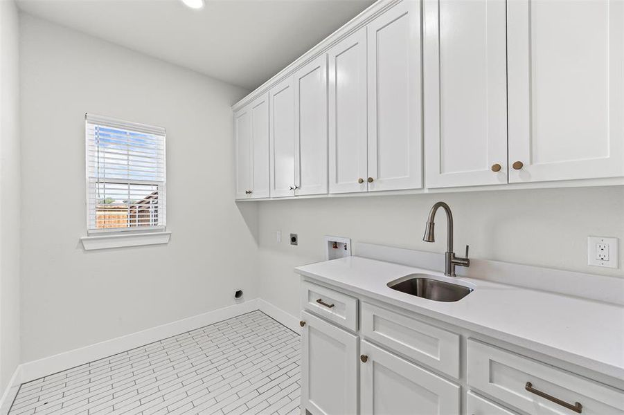 Washroom featuring hookup for a washing machine, light tile patterned floors, cabinet space, hookup for an electric dryer, and recessed lighting Washroom featuring hookup for a washing machine, light tile patterned floors, cabinet space, hookup for an electric dryer, and recessed lighting