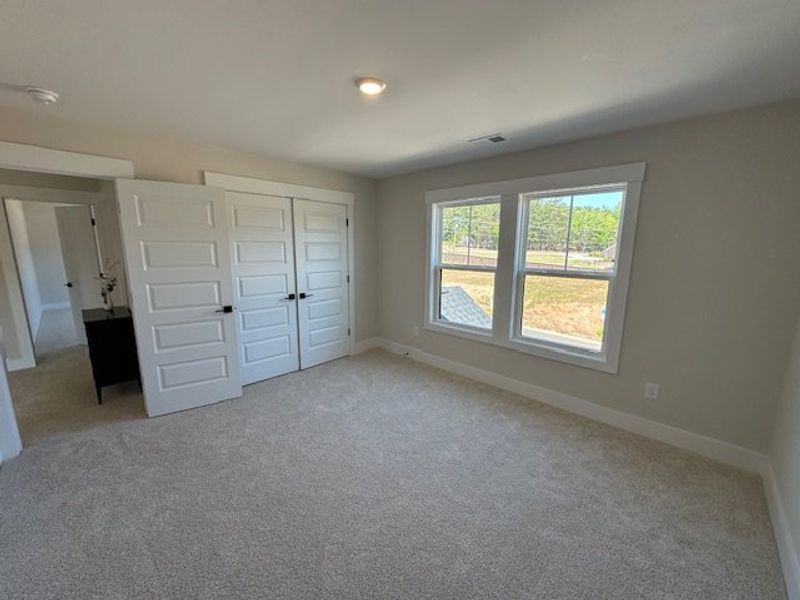 This spacious bedroom offers ample light and comfo