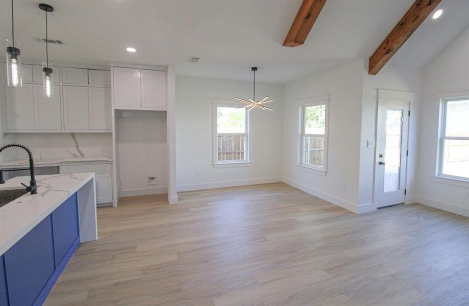 Kitchen with white cabinetry, hanging light fixtures, recessed lighting, light wood-style flooring, and a chandelier Kitchen with white cabinetry, hanging light fixtures, recessed lighting, light wood-style flooring, and a chandelier