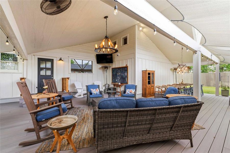 Expansive covered porch featuring a vaulted ceiling, board and batten wall paneling, recessed lighting, and a durable composite deck surface