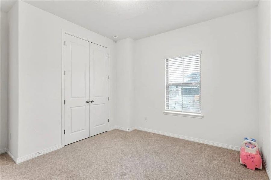 Unfurnished bedroom with light colored carpet and a closet Unfurnished bedroom with light colored carpet and a closet
