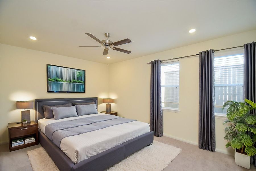 This well-lit bedroom offers a tranquil retreat with ample natural light.