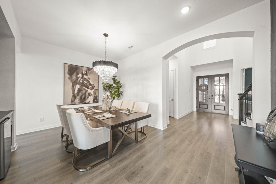 Enter underneath the arched entry into the formal dining room with Revwood floors, tall ceilings and a decorative chandelier which creates an elegant setting for gatherings.