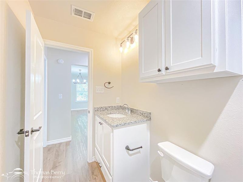 Bathroom with light wood-style floors, vanity, and a chandelier Bathroom with light wood-style floors, vanity, and a chandelier