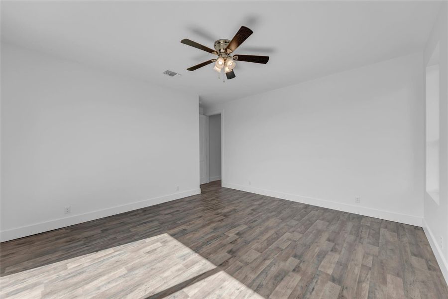 Guest Bedroom 1; Smooth wood-look plank flooring pairs with clean white walls in this versatile living space.