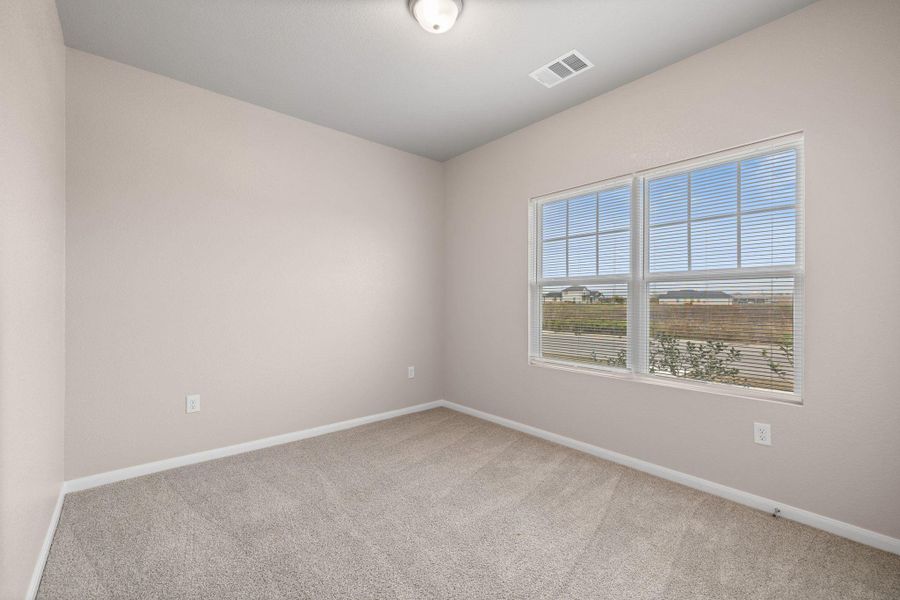 Unfurnished room featuring baseboards and light carpet