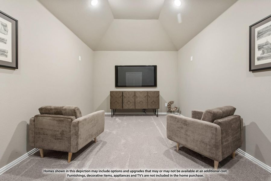 Media room with vaulted ceiling, two armchairs, wall-mounted TV, and wood console cabinet on carpet Media room with vaulted ceiling, two armchairs, wall-mounted TV, and wood console cabinet on carpet