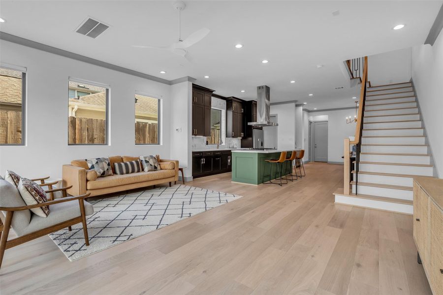 Viewed from the corner of the room, this angle highlights the living area, while the kitchen and formal dining area can be seen in the background, showcasing the home's open and connected layout.