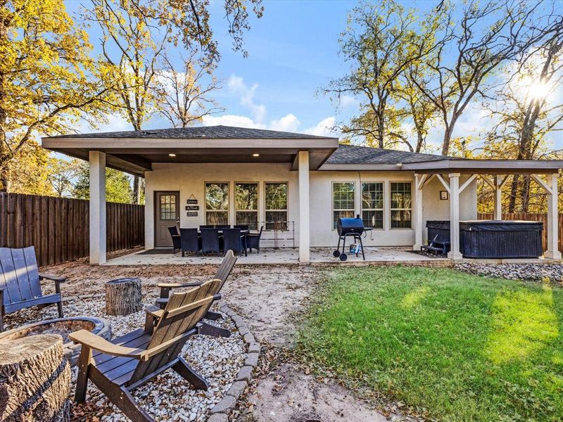 Back of property featuring a hot tub, stucco siding, and a patio area