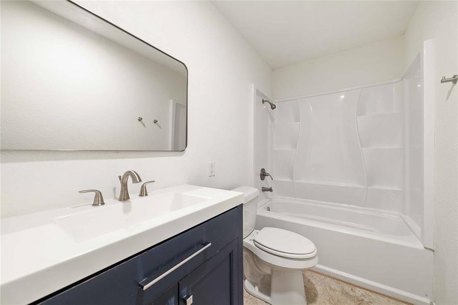 Bathroom featuring shower / bathing tub combination, vanity, and toilet Bathroom featuring shower / bathing tub combination, vanity, and toilet