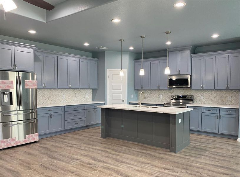 A contemporary kitchen features sleek cabinetry, a spacious island with a sink, and integrated stainless steel appliances. A contemporary kitchen features sleek cabinetry, a spacious island with a sink, and integrated stainless steel appliances.