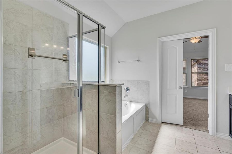 Bathroom featuring independent shower and bath, lofted ceiling, ceiling fan, and tile patterned flooring