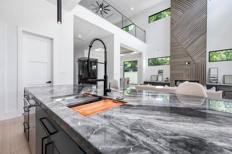 Oversized island with sink equipped with a motion-sensored faucet, built-in cutting board, colander, and additional cutting board, designed for maximum functionality and convenience.