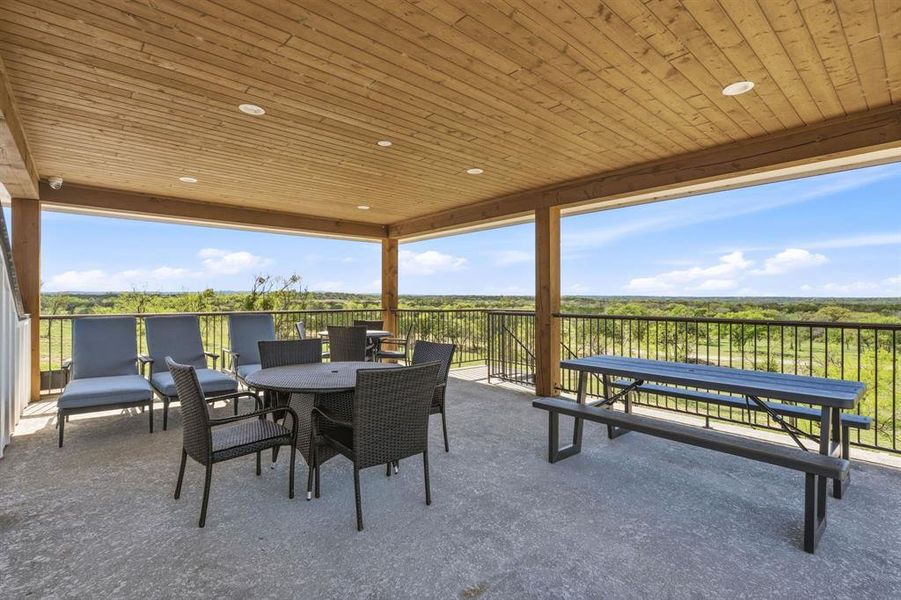 An inviting covered patio offers panoramic natural vistas, perfect for relaxation or outdoor dining.