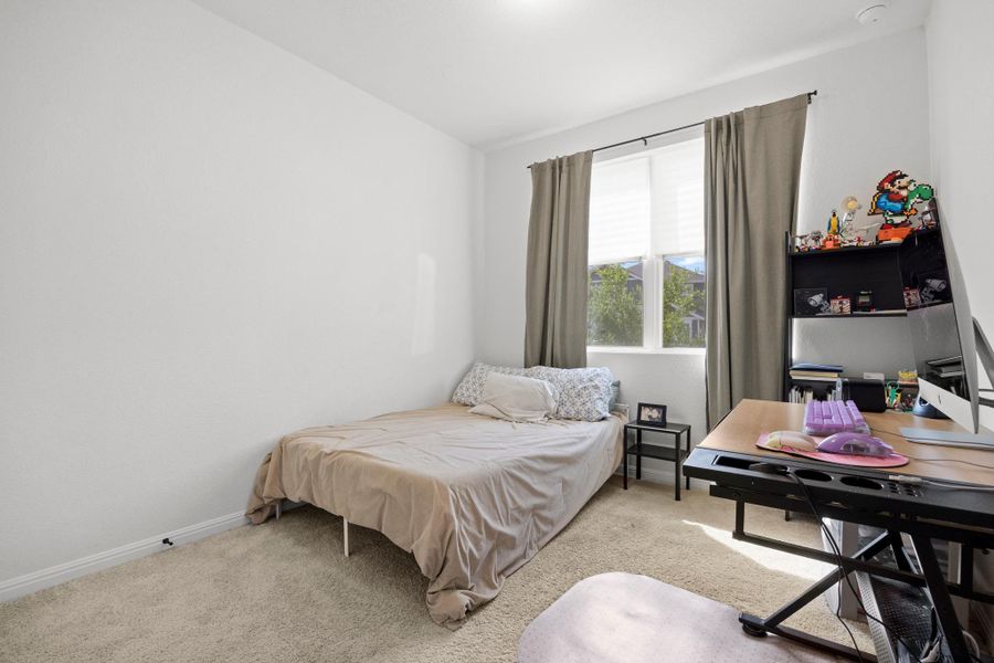 Bright room featuring a window with blinds, carpet flooring, and white walls