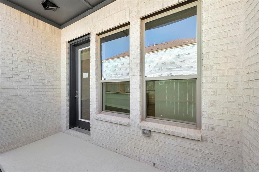 Property entrance with a patio area and brick siding